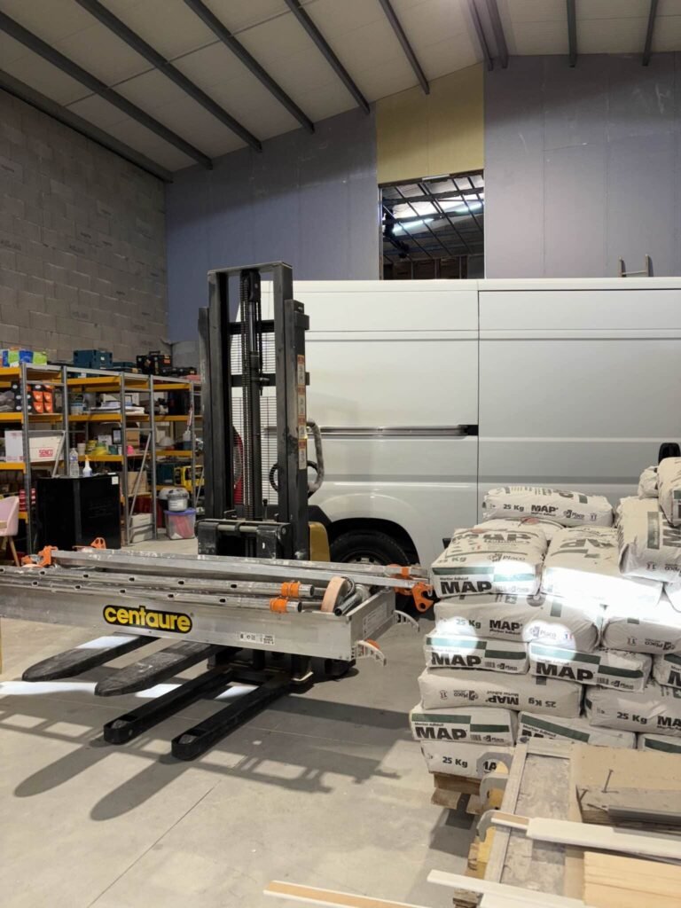 Intérieur de l’entrepôt SPN avec chariot Centaure, véhicule et sacs de mortier MAP