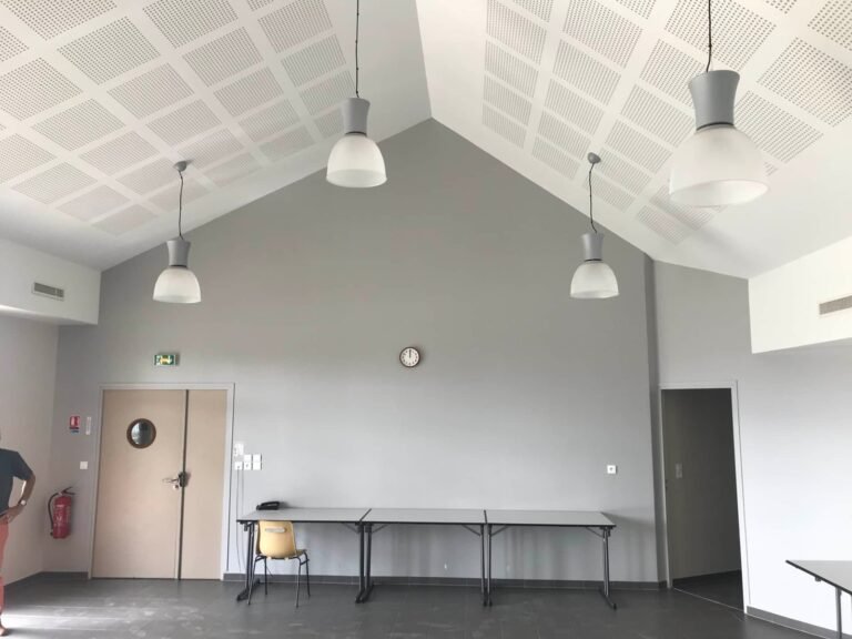 Plafond acoustique perforé installé dans une salle communale avec éclairages suspendus pour réduction du bruit — Société de Pose Normande
